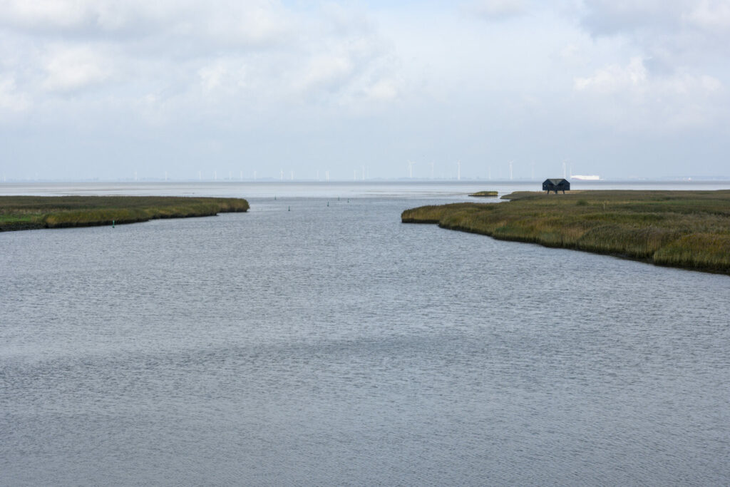 Uitzicht op de Dollard met aan de overkant de Duitse stad Emden en rechts de Kiekkaaste