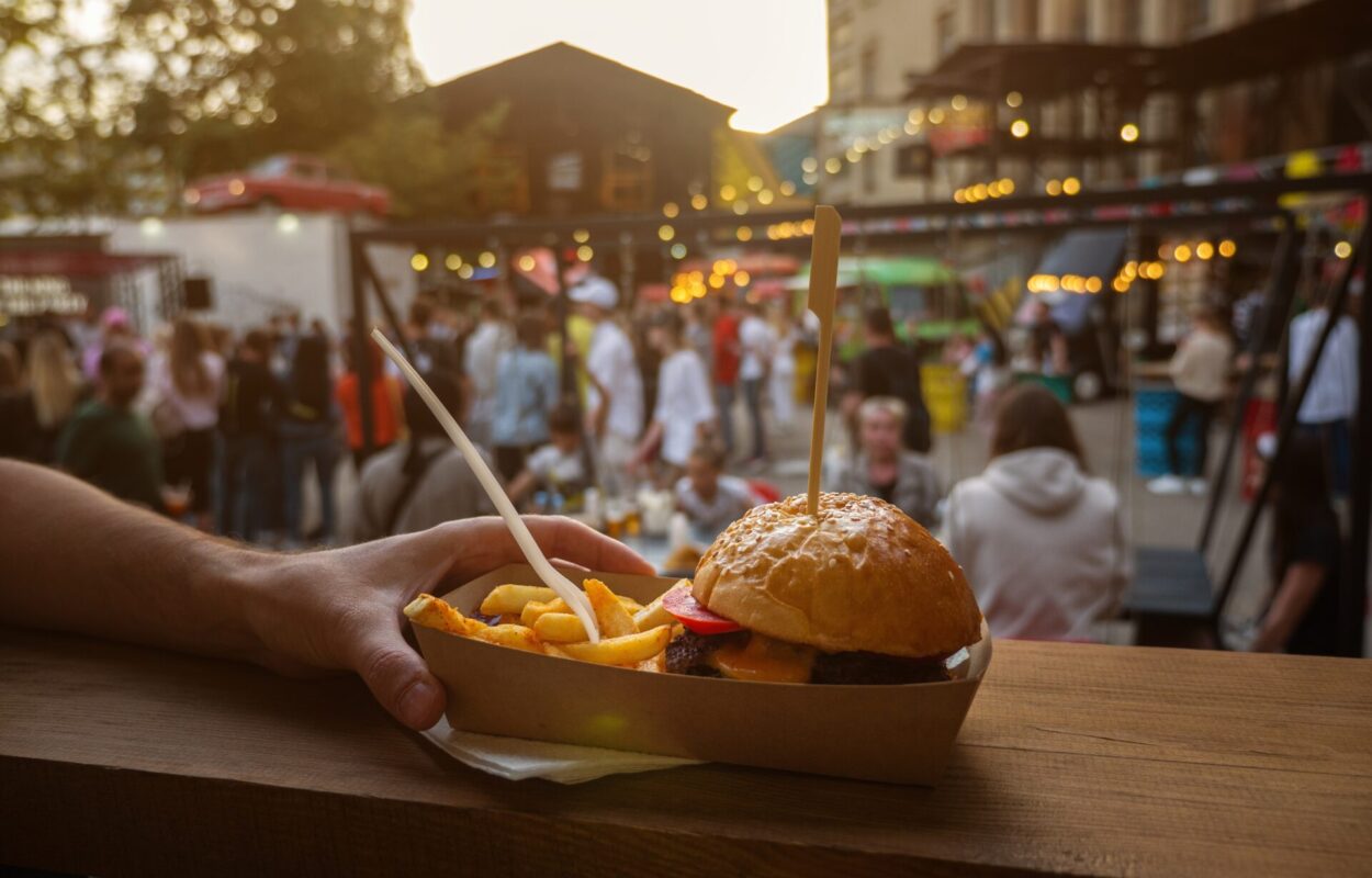 Man,Hands,Holding,Street,Food,Burger,With,French,Fries,On